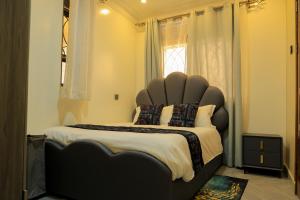 a bedroom with a large bed with a large headboard at Luxury Gem in Nsambya 1km from American Embassy in Kampala