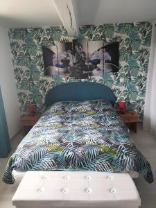 a bedroom with a bed with a blue comforter at Gite Villarnoux in Beauvilliers