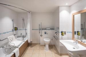 a bathroom with a toilet and a sink and a shower at Holiday Inn Farnborough by IHG in Farnborough +40 photos