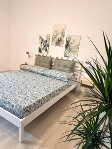 a bed in a room with two potted plants at Nido Flegreo in Pozzuoli