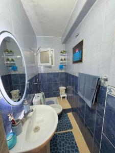 a bathroom with a sink and a toilet and a mirror at Apartment in Martil in Martil