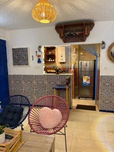 a living room with a heart chair and a kitchen at Apartment in Martil in Martil
