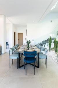 a dining room with a long table and blue chairs at Luxury Villa with Heated Pool & Private cinema in Marrakesh