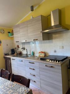 a kitchen with white cabinets and a stove top oven at Casa vacanze di Angelo in Isnello