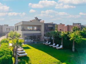 an aerial view of a house with lounge chairs and palm trees at Luxury Villa with Heated Pool & Private cinema in Marrakesh
