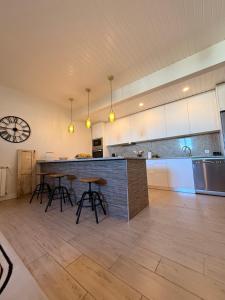 Una cocina con encimera y taburetes en una habitación. en Casa Do Cruzeiro Apartment, en Armamar
