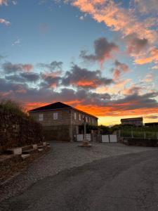 un edificio con una puesta de sol en el fondo en Casa Do Cruzeiro Apartment, en Armamar