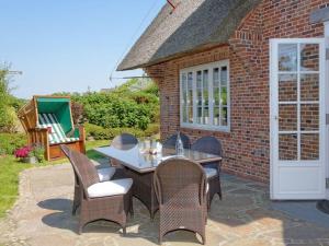a patio with a table and chairs and a building at Prahl-Hues-5 in Kampen +6 photos