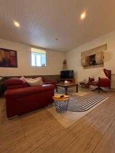 Una sala de estar con un sofá rojo y una mesa. en Casa Do Cruzeiro Apartment, en Armamar