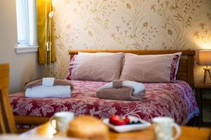 a bedroom with a bed with two towels on it at Courtyard Bothy in Grantown on Spey +46 photos