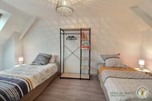 een slaapkamer met 2 bedden en een kast bij Pres des nouelles in Plérin +18 foto's