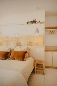 a bedroom with a large bed with a bench next to it at Maison cosy avec terrasse, à 5 minutes des plages in Porspoder