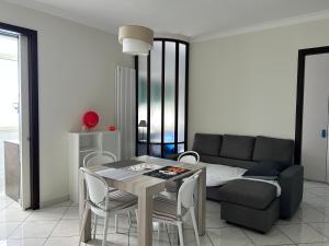 a living room with a table and a couch at Giaco Symphony Stay in Bari
