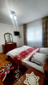 Vadu MoţilorにあるCabana La Cucuのベッドルーム1室(ツインベッド2台、鏡付)