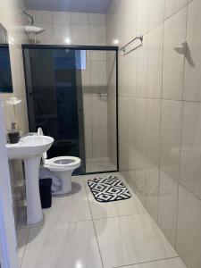 een badkamer met douche, toilet en wastafel bij AP completo a 5 min da Praia, Itapema-SC in Itapema