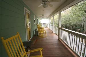 eine Veranda mit Schaukelstühlen und einem Deckenventilator in der Unterkunft Watercolors in Edisto Island