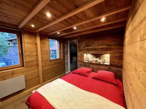 a bedroom with a red bed in a log cabin at Splendide appartement style chalet classé 4 étoiles, terrasse face à la montagne in La Bresse
