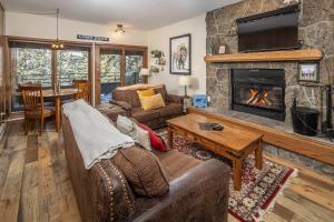 a living room with a couch and a fireplace at Snowflake at Skycrest in Big Sky
