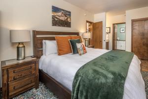 a bedroom with a large bed and a night stand at Snowflake at Skycrest in Big Sky +20 photos