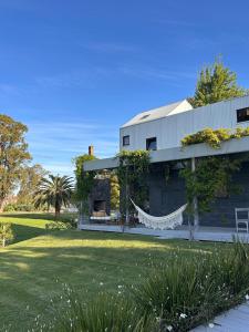 ein Haus mit einer Hängematte vor einem Hof in der Unterkunft Casa Río Mío in Colonia del Sacramento