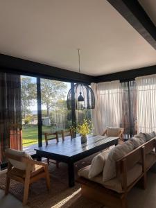 ein Wohnzimmer mit Tisch und Couch in der Unterkunft Casa Río Mío in Colonia del Sacramento