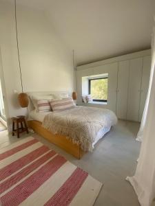 Schlafzimmer mit einem Bett, einem Fenster und einem Teppich in der Unterkunft Casa Río Mío in Colonia del Sacramento