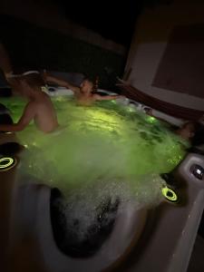 two men in a bath tub with green water at Casa Matei Costinești in Costinesti