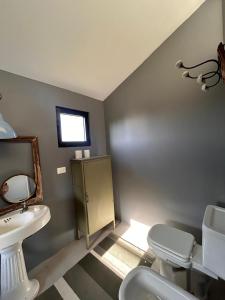 ein Badezimmer mit Waschbecken, Toilette und Spiegel in der Unterkunft Casa Río Mío in Colonia del Sacramento + 27 Fotos