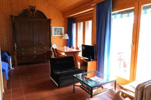 uma sala de estar com um sofá e uma mesa de vidro em Chalet Kiri 8 personnes Sur les hauteurs d Evolene em Evolène