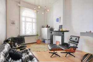 a living room with leather furniture and a fireplace at Architectonisch en kunsthistorisch droomverblijf in Antwerpen in Antwerp