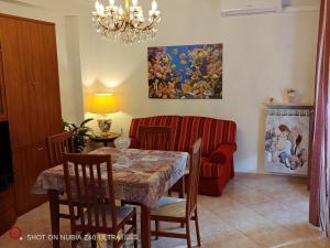 a dining room with a table and a couch at Atlantis Apartment Trieste in Trieste