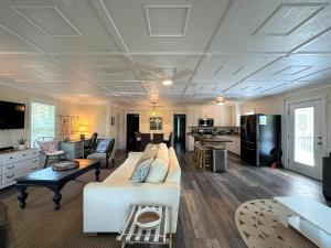 a living room with a white couch and a kitchen at Serenity Now in Edisto Island