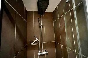 a shower in a bathroom with brown tiles at Saint maurice RER A direct Disney in Joinville-le-Pont +2 photos