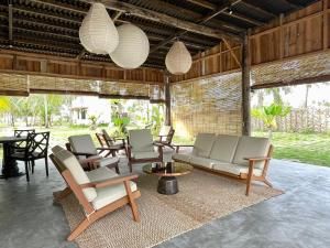 a living room with chairs and tables and lights at LAWA Bintan Berakit Village Cottage in Berakit