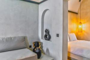 a bedroom with a bed and a couch with a chair at 180 Suites in Imerovigli +65 photos