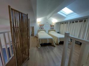 une chambre avec deux lits et un balcon avec une fenêtre dans l'établissement Bormes les Mimosas, Hameau de Cabasson, à 400m de la mer et du fort de Bregançon, Villa classée 3 étoiles, de 2 à 8 personnes, à Bormes-les-Mimosas