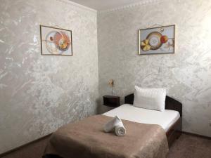 a bedroom with a bed and two pictures on the wall at nur m hotel in tashkent in Yakkasaray