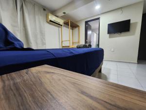a bedroom with a blue bed and a tv at Casa Seloria in Cancún