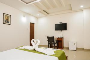 a bedroom with a bed with a heart shaped towel at White Fern Stays Serviced Apartments - Gachibowli in Hyderabad