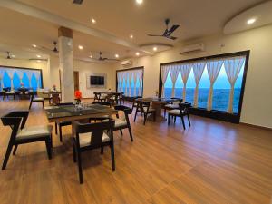 un restaurant avec des tables et des chaises et de grandes fenêtres dans l'établissement Resort K Sea View Mandarmoni, à Mandarmoni