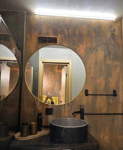 a bathroom with a round sink and a mirror at Hugo Airport in Mārupe +3 photos