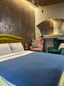 a bedroom with a blue bed and two chairs at Hugo Airport in Mārupe +7 photos