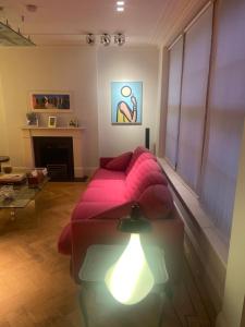 a living room with a pink couch and a table at 1 callcoot Road in London