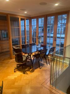 a table and chairs in a room with windows at 1 callcoot Road in London