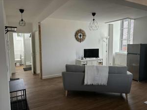 a living room with a couch and a tv at Appartement moderne proche de l'autoroute in Combronde