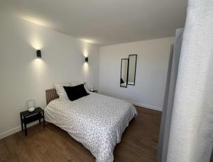 Un dormitorio con una cama con un edredón blanco y negro. en Appartement, en Combronde
