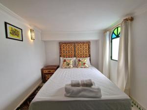 a bedroom with a bed with two towels on it at AMY Brothers Apartments in Tangier