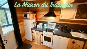 a kitchen with a refrigerator and a stove top oven at La maison du Trappeur et la cabane des sources in Le Mont-Dore