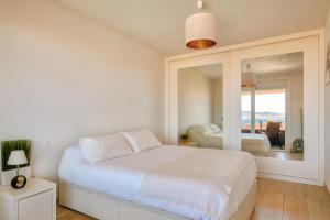una camera da letto bianca con un letto e uno specchio di Apart CityMar 24h Terraza y vistas Ria Vigo a Vigo Altre 13 foto
