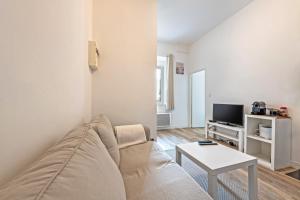 a living room with a couch and a table at Les Capucins - T2 tout confort in Brest